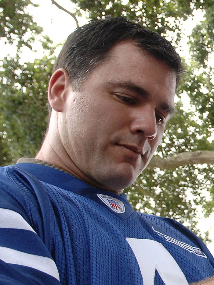 Adam Vinatieri in a blue football jersey outdoors