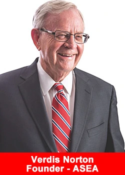 Portrait of Verdis Norton smiling in a suit and tie