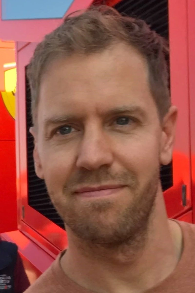 Portrait of Sebastian Vettel in front of a red Ferrari background