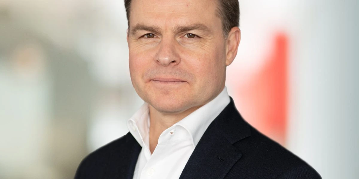 Portrait photo of Christophe de Vusser in a dark suit and white shirt