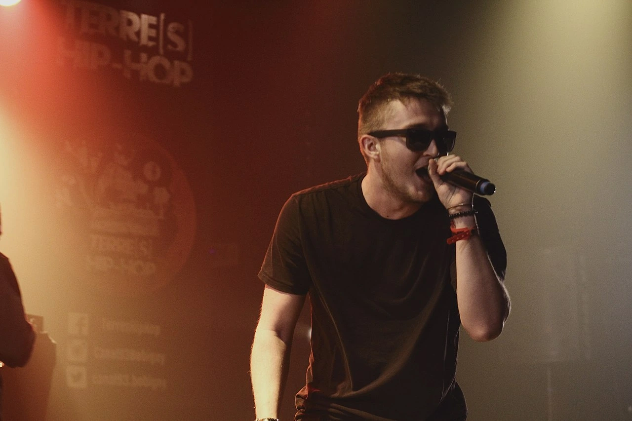 Vald performing on stage with microphone and sunglasses