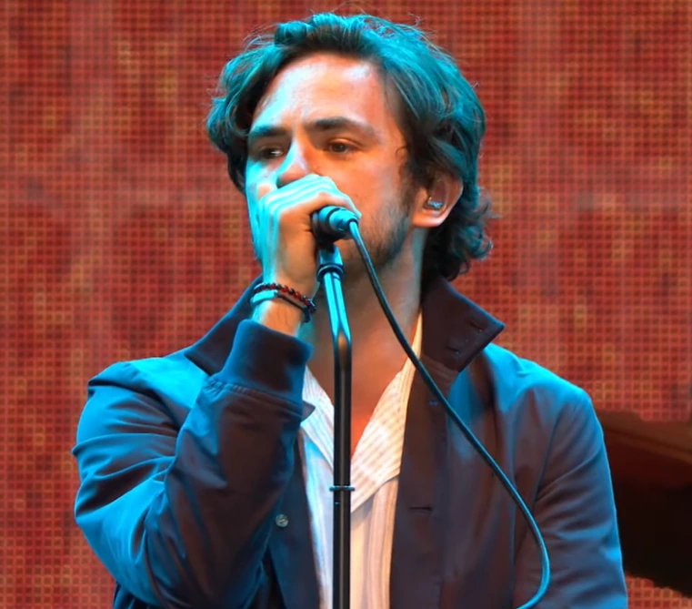 Jack Savoretti performing on stage with a microphone